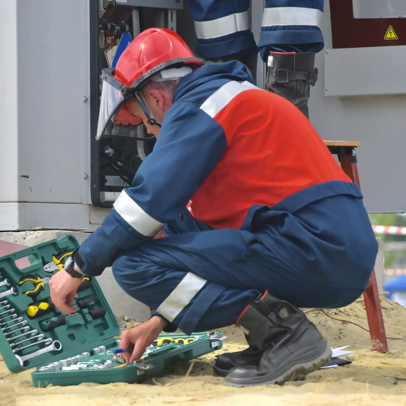 man in red and black jacket wearing black pants and red helmet holding green and black