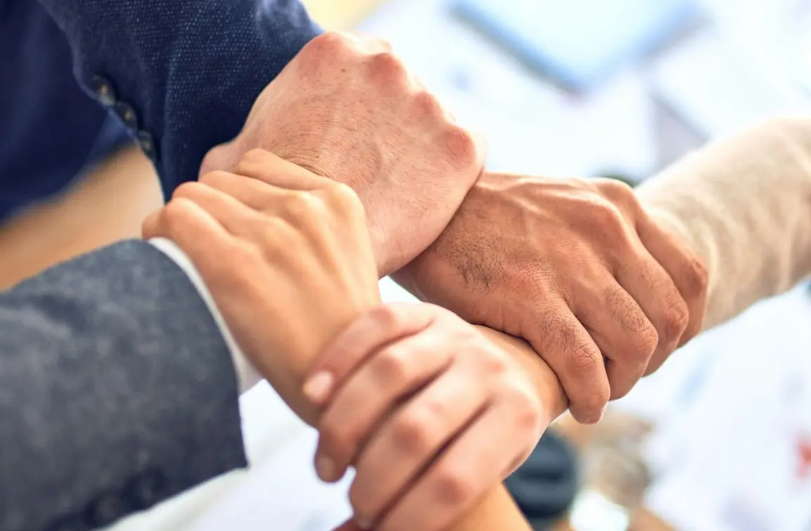 person in black long sleeve shirt holding persons hand