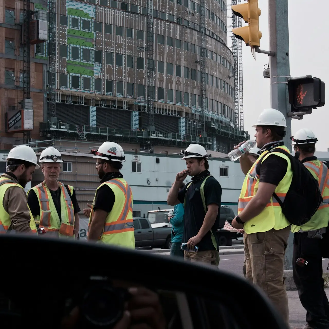people in yellow and black jacket standing on road during daytime