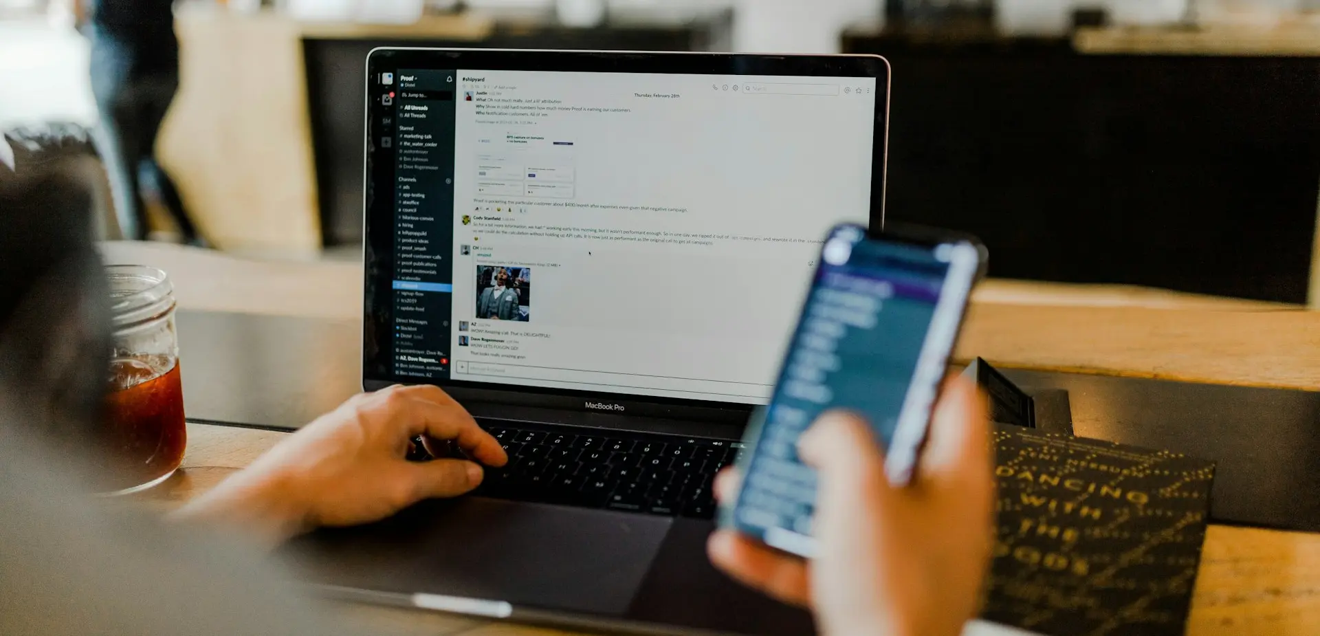 person using phone and laptop
