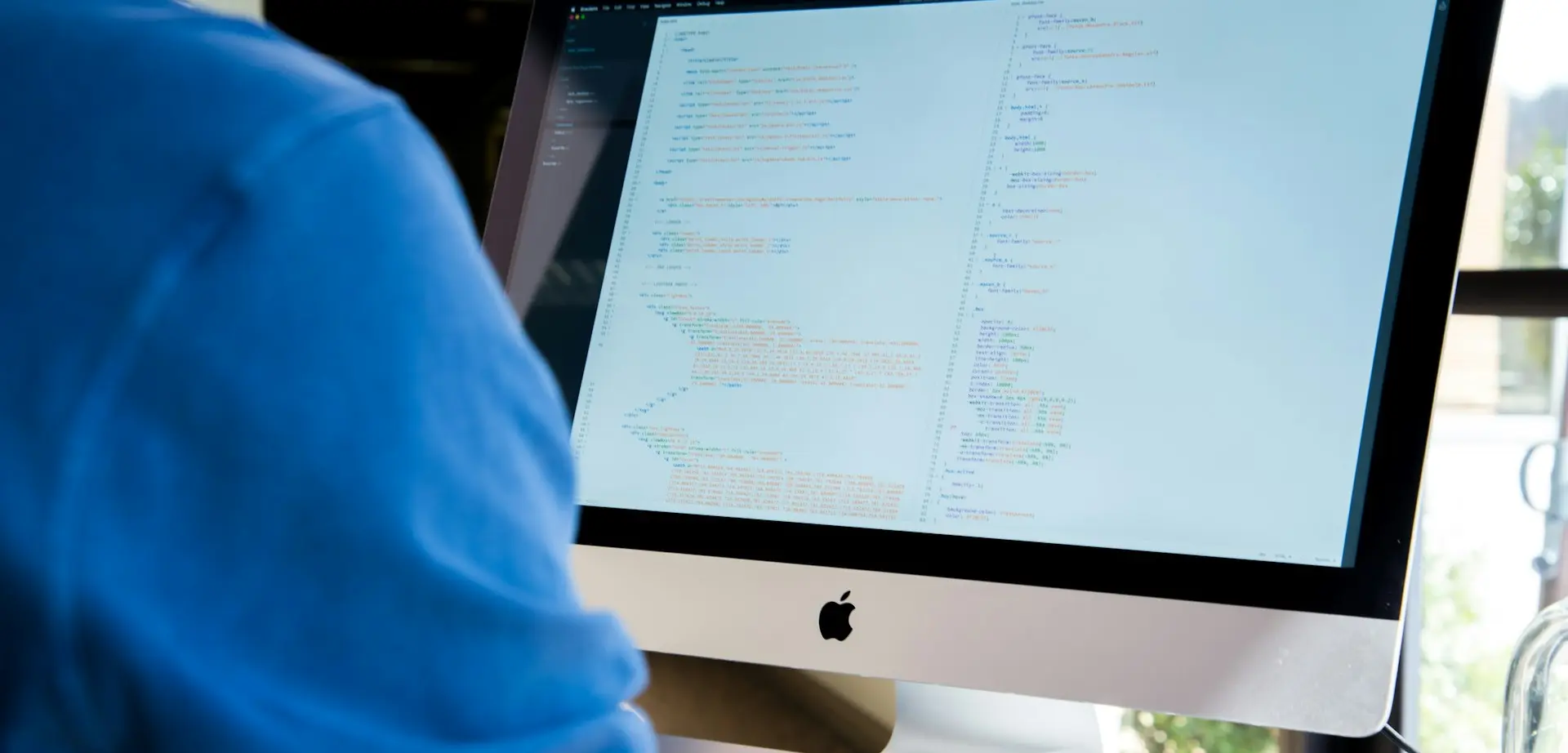 person facing monitor while typing during daytime