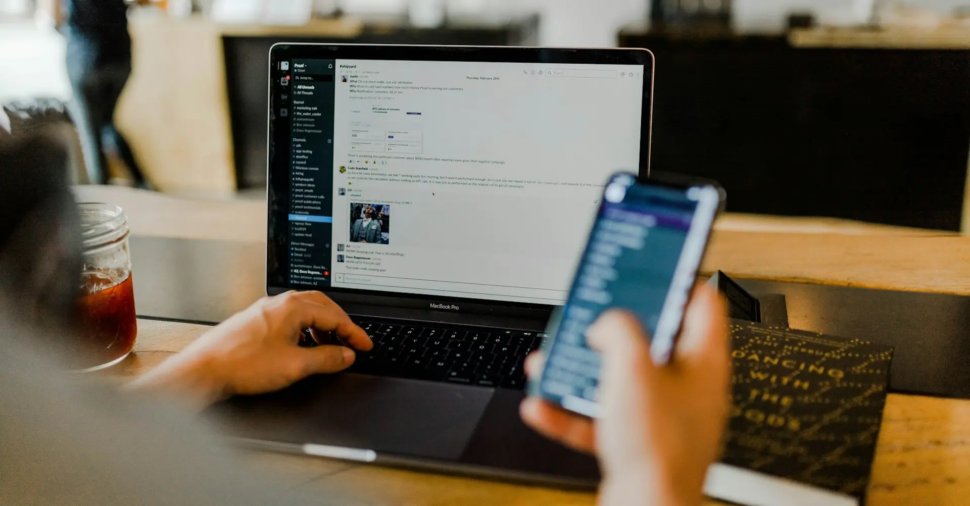 person using phone and laptop