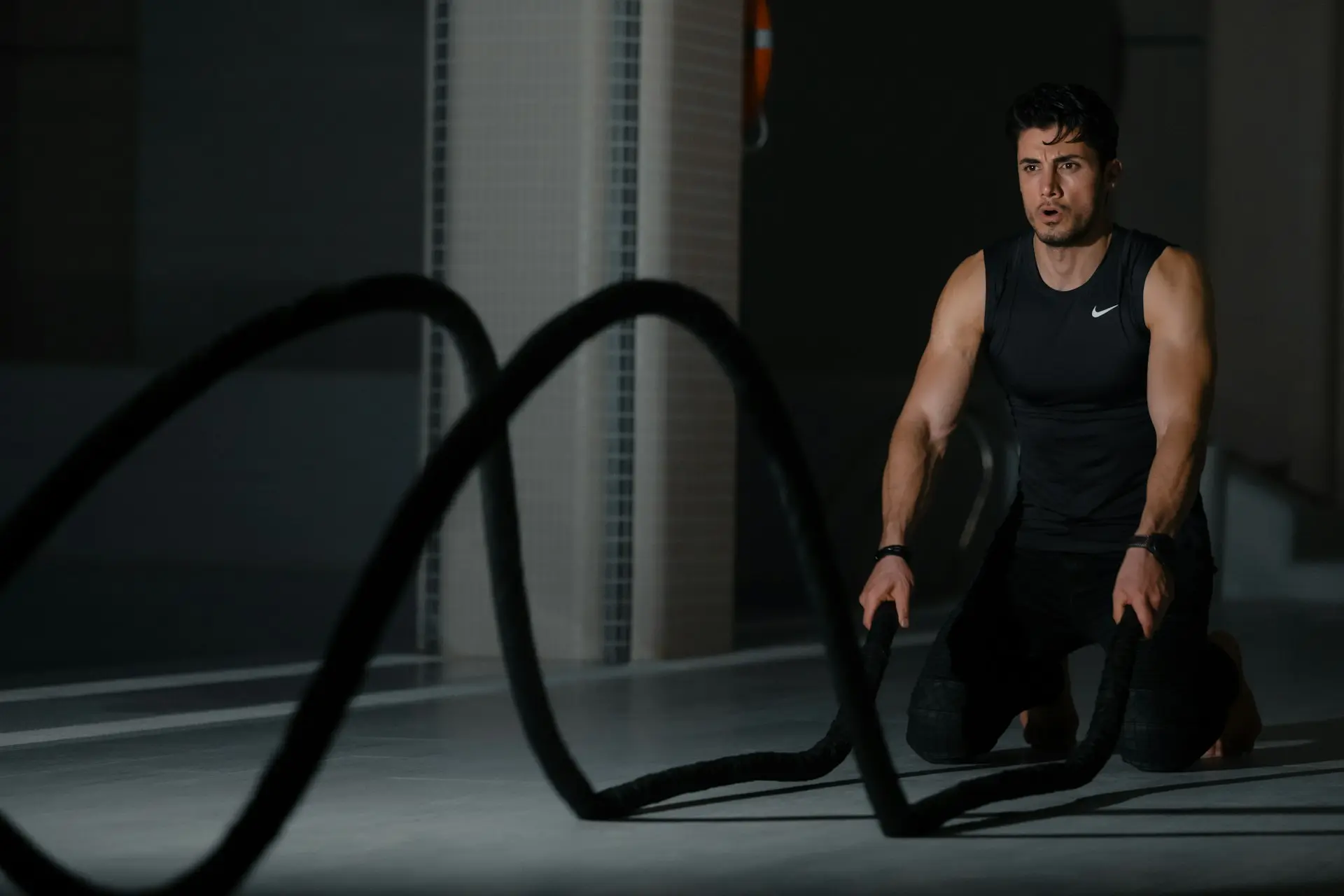 woman in black tank top and black pants sitting on black exercise equipment